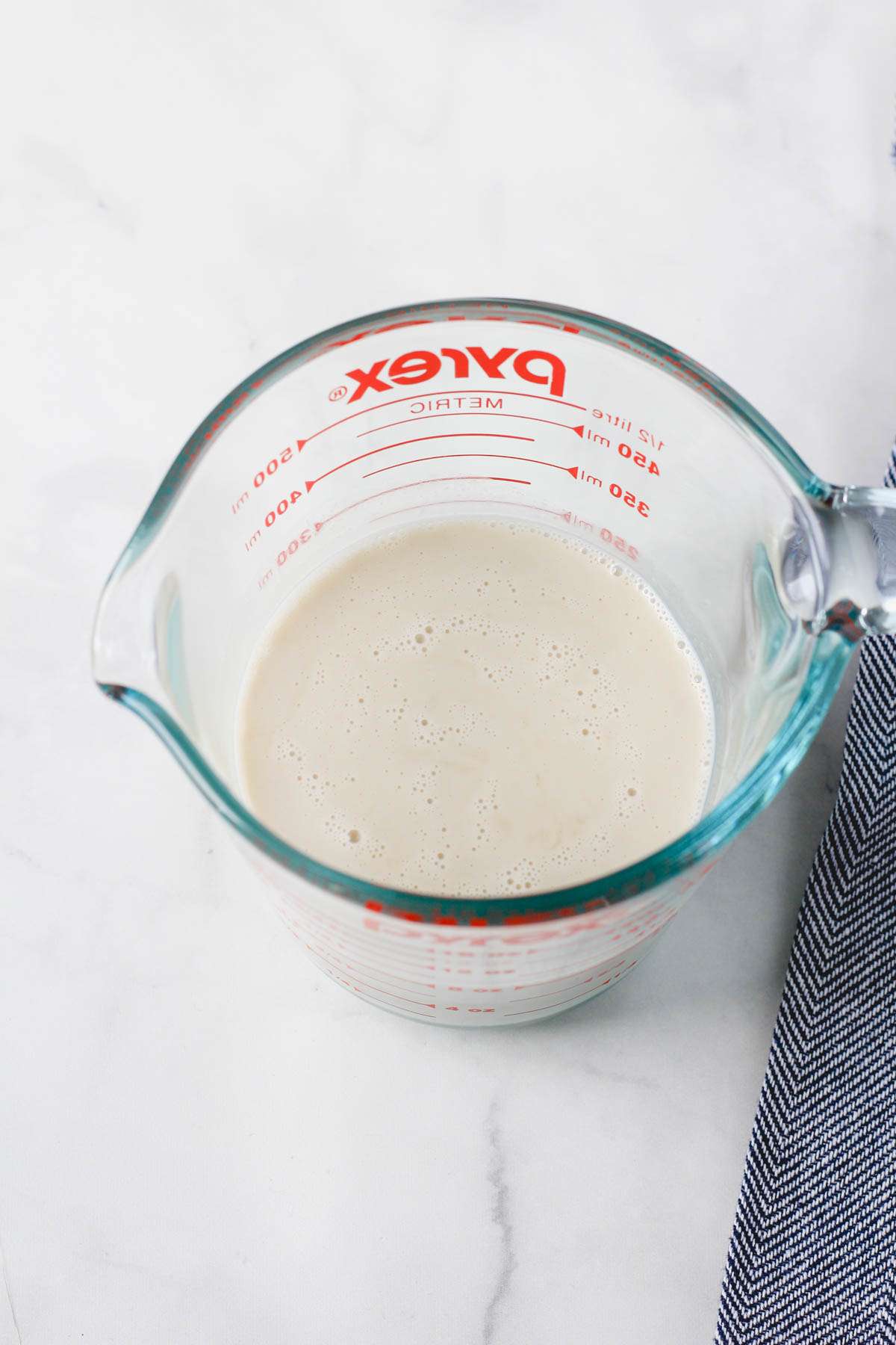 A top down picture of dairy-free buttermilk in a liquid measuring cup.