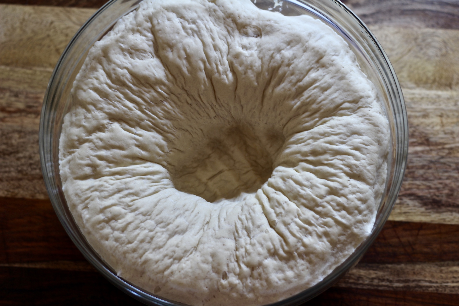 Bowl of dough with a punch in the dough.