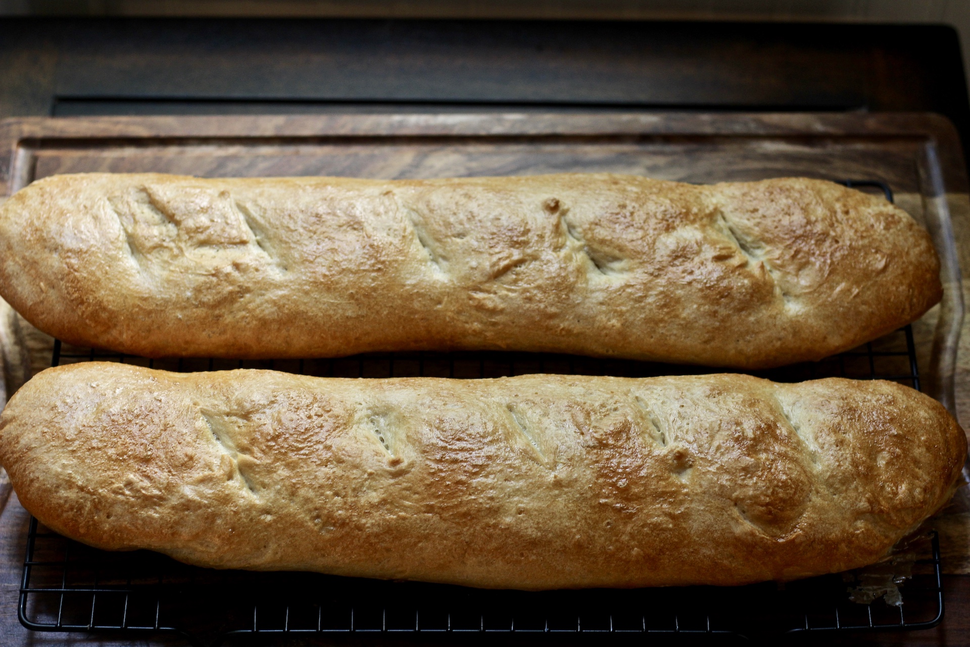 Two loaves of French Bread on a wooden cutting board.