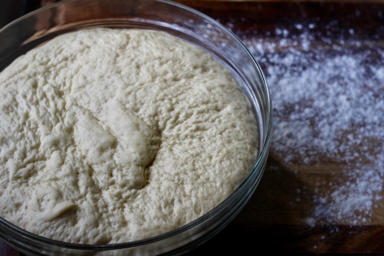 Raw Garlic knots dough rising in a bowl.