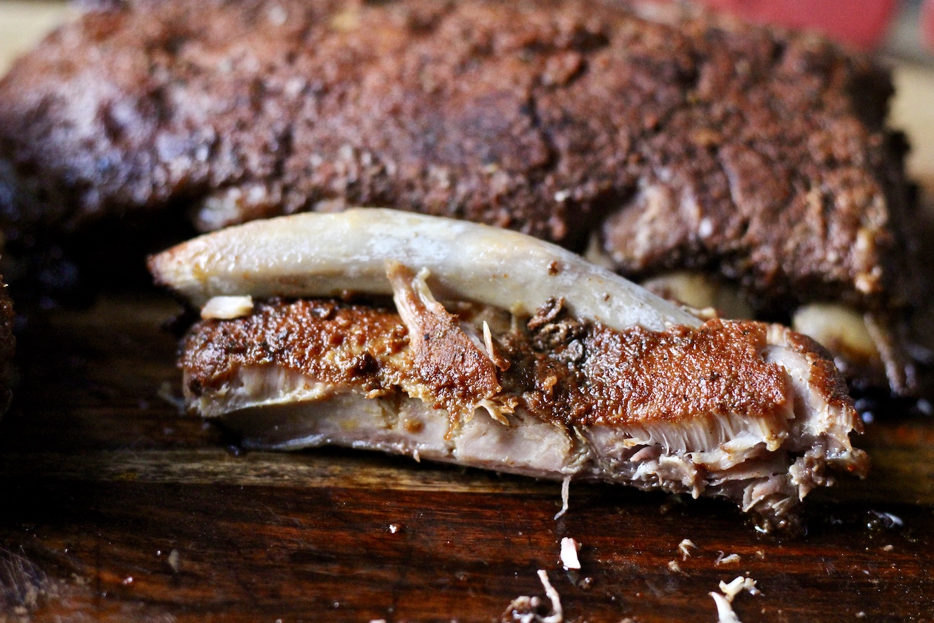 Dry-Rubbed Slow Cooker Ribs on a cutting board with the bone hanging out