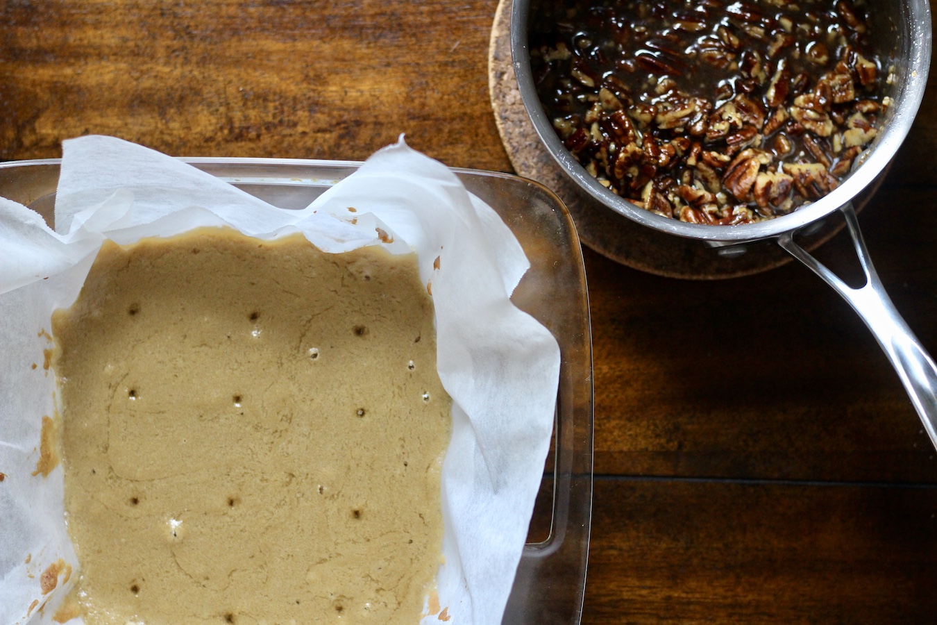 Blondie base with the pecan mixture in the top right in a saucepan.