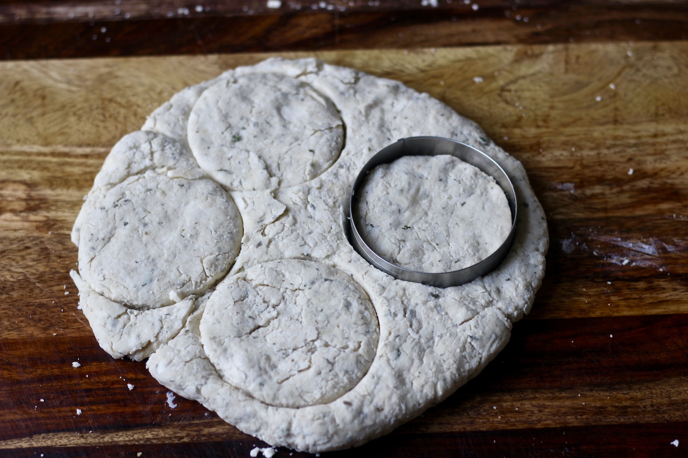 A round disk of biscuit dough with 4 circles cut out.
