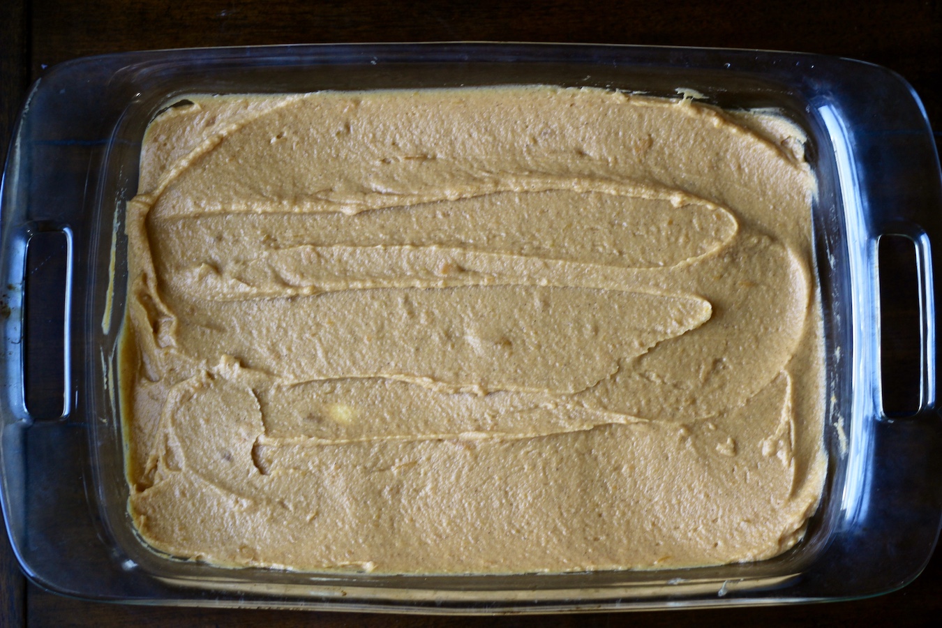 Unbaked sweet potato casserole in a pyrex dish.