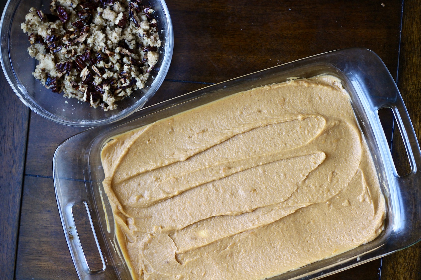 Unbaked sweet potato casserole with topping to the side.