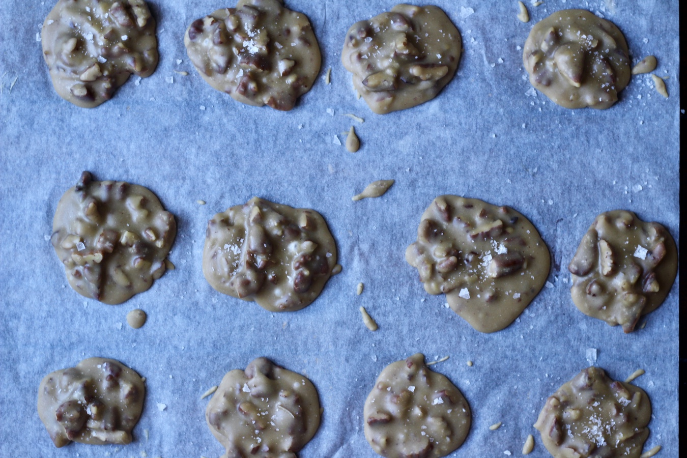 Dried pecan pralines on a parchment paper.