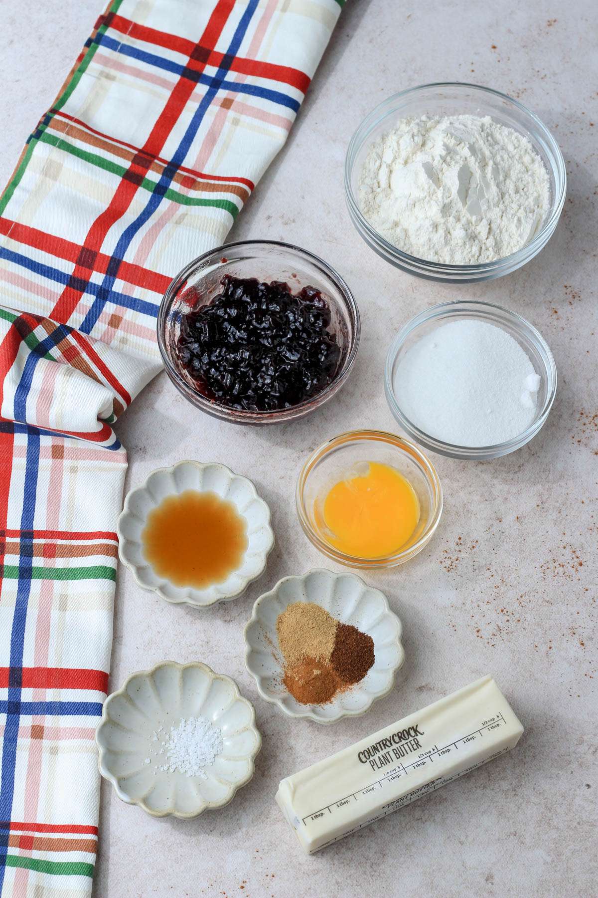 Ingredients for spiced blackberry thumbprint cookies on a counter.
