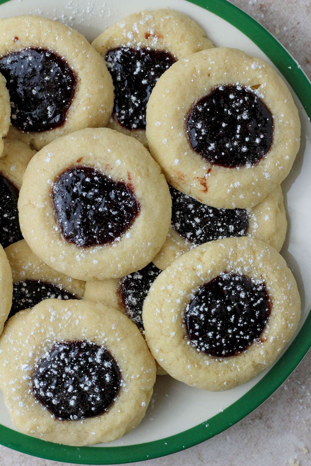 Spiced blackberry thumbprint cookies on a white and green plate.