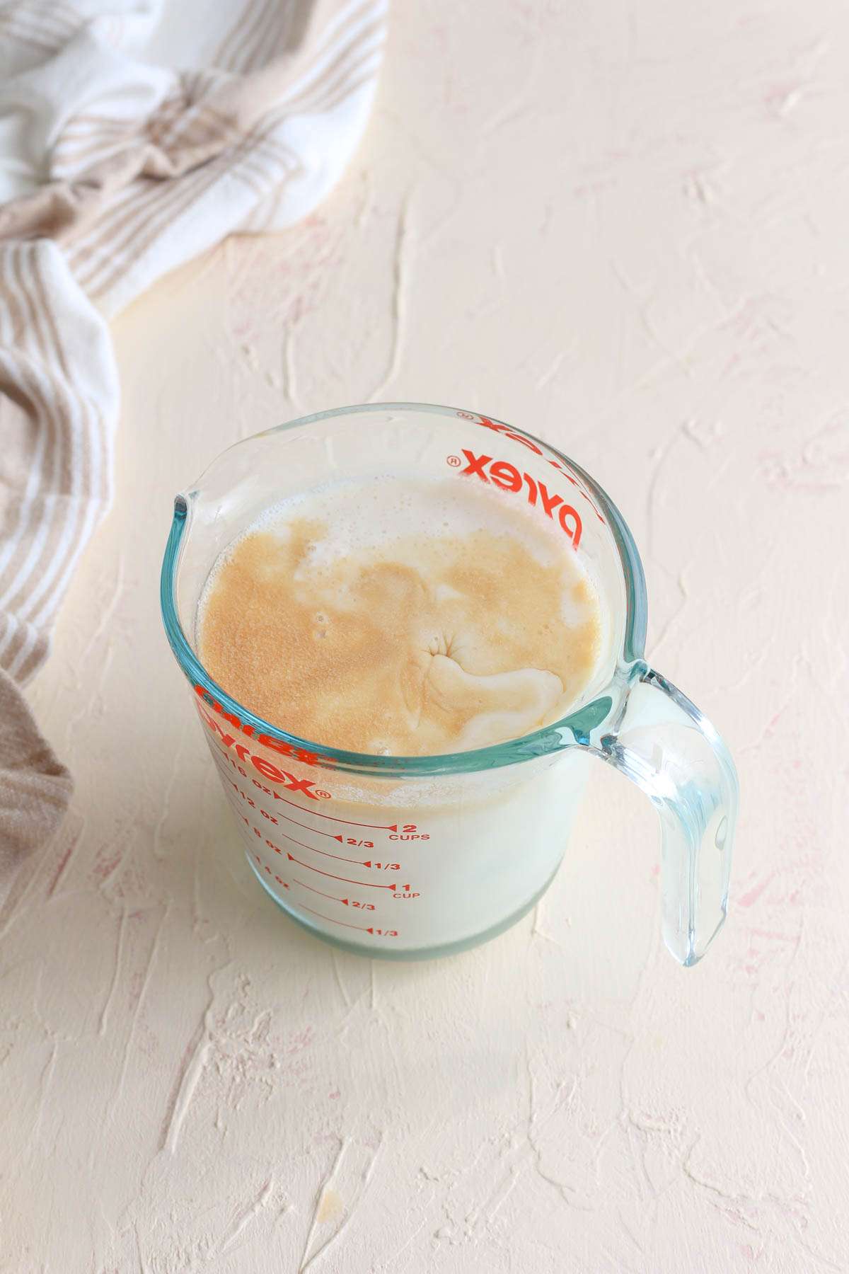 A liquid measuring cup with wet ingredients for dairy free buttermilk pancakes.