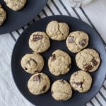 Two blue plates with lactation cookies on a white and blue striped dish towel.