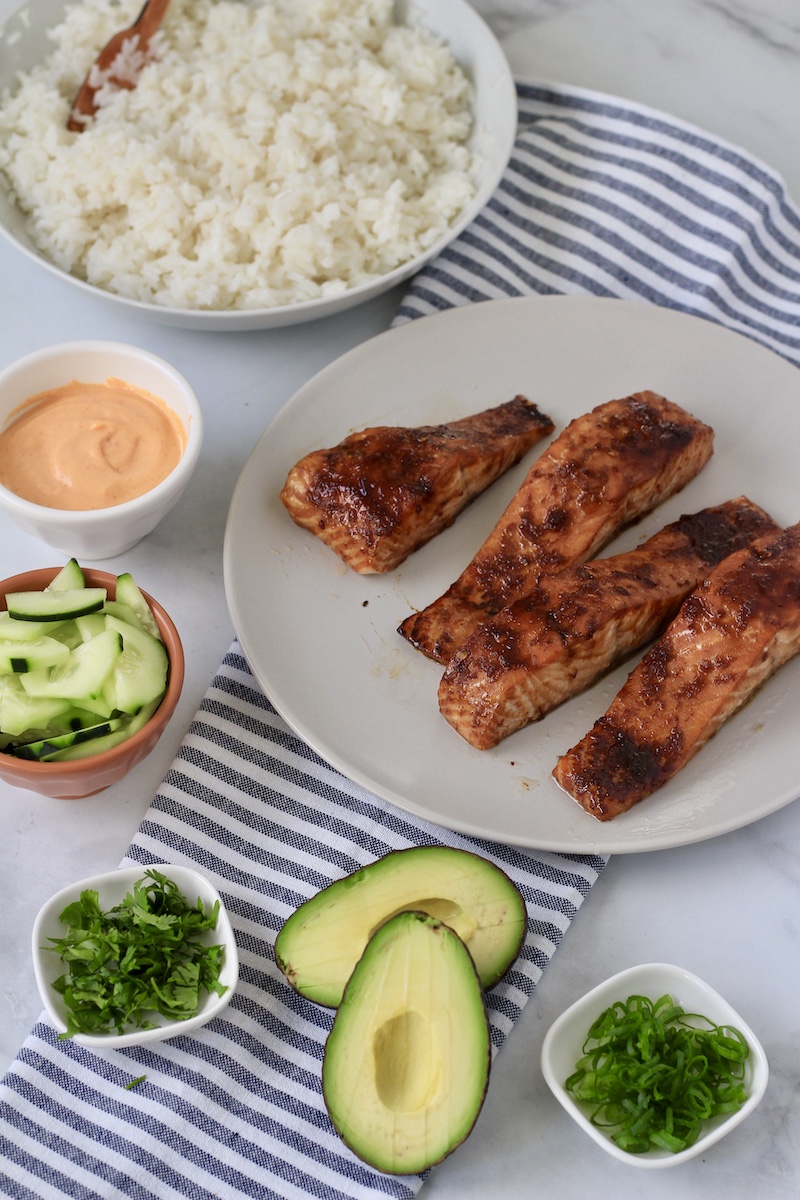 All of the prepared ingredients for salmon avocado bowls on a counter before assembling the bowls.