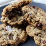 A pile of dark chocolate oatmeal craisin cookies on a blue plate.