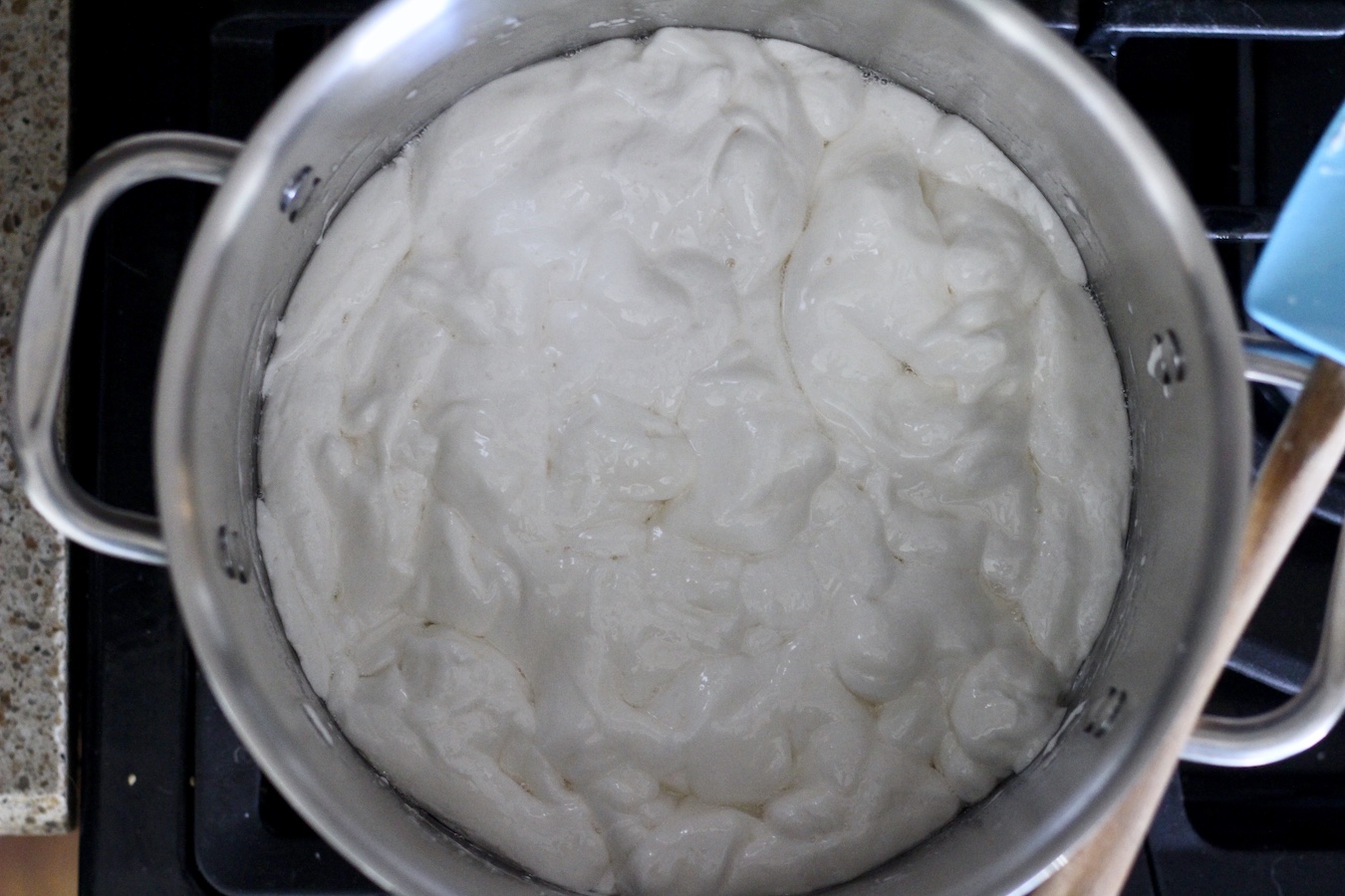 A stainless steel pot with coconut oil and marshmallows melting.