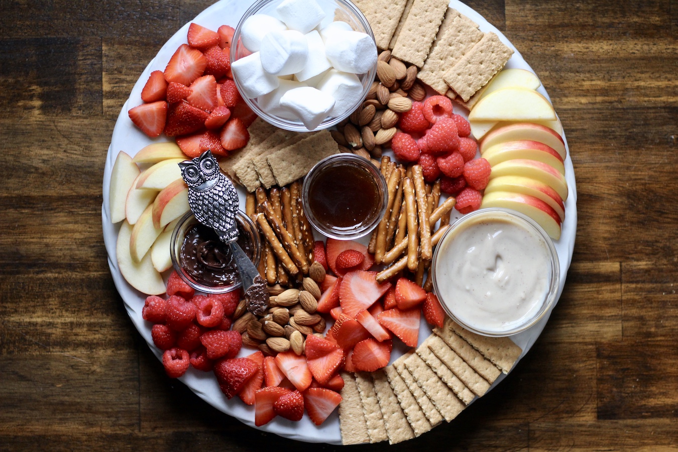 The whole valentine's day dessert board on a marble board on a wooden table.