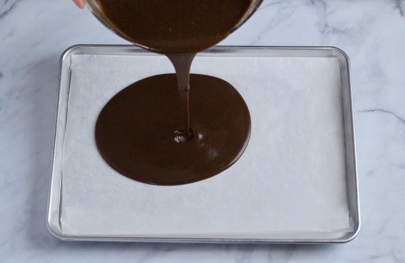 Texas sheet cake batter being poured into a prepared sheet pan.