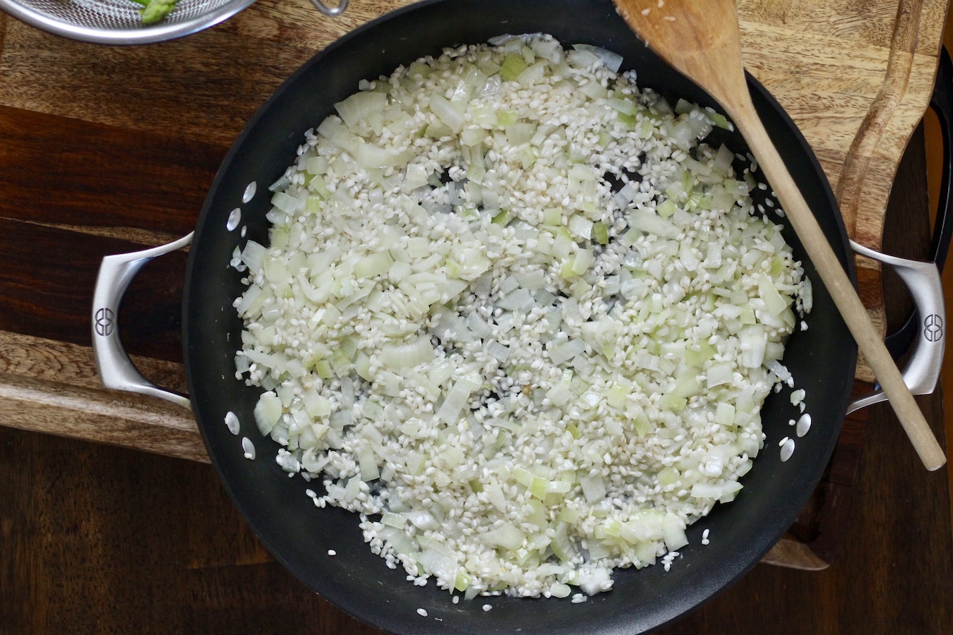 Rice and onion in the skillet during the cooking process.