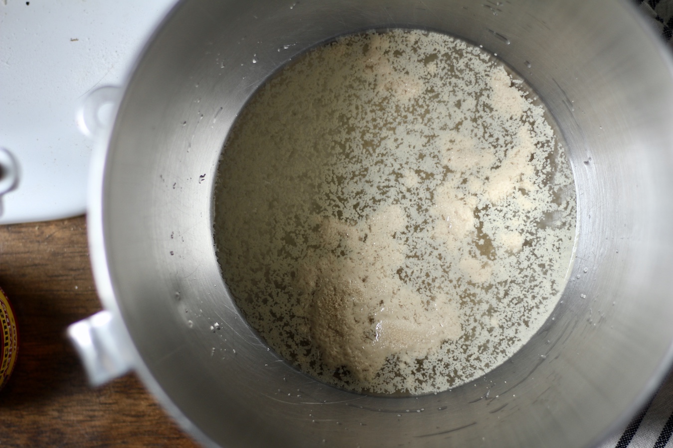 Yeast mixed with the warm water in a silver bowl.