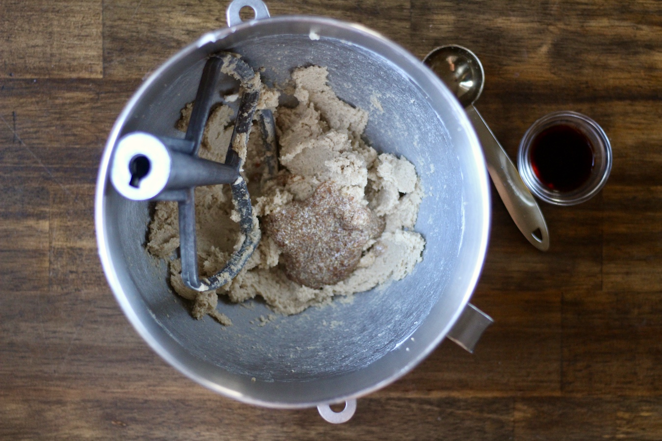 Flax egg with vegan butter and sugar mixture in a mixing bowl on a wooden table.