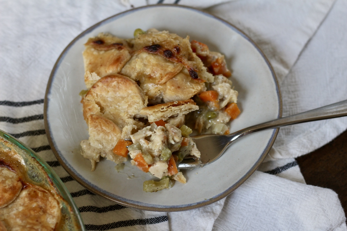 A slice of chicken pot pie with a bite on a fork.
