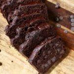 sliced chocolate banana bread on a cutting board with chocolate chips.