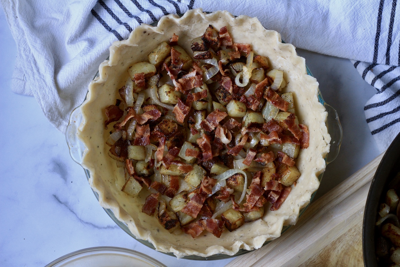The quiche crust filled with potato, bacon, and onion.