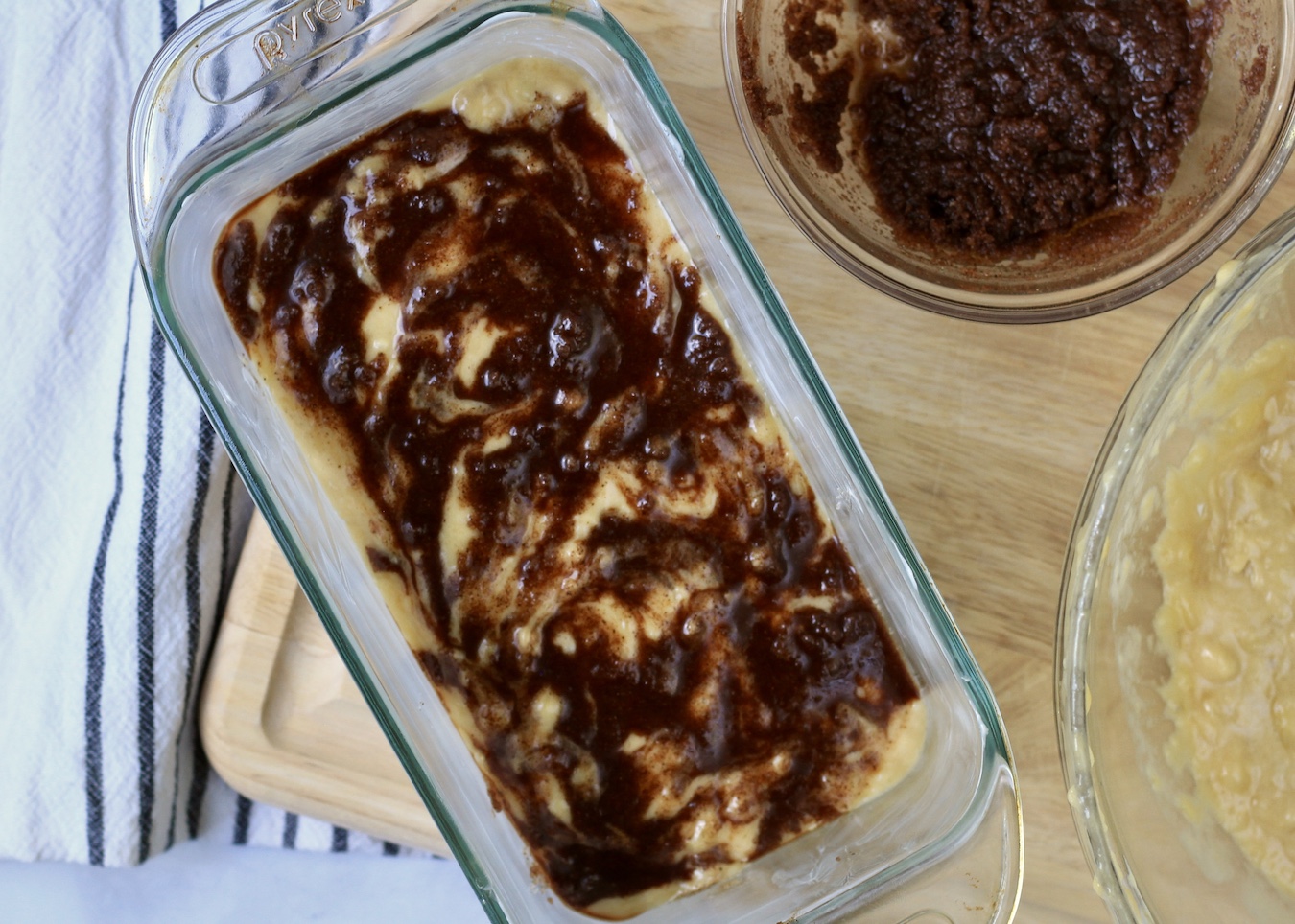 Cinnamon swirl banana bread in a bread pan on a wooden counter.