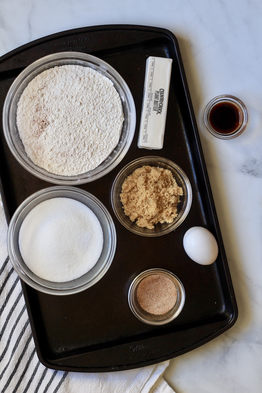 The ingredients before mixing the sugar and vegan butter on a cookie sheet.