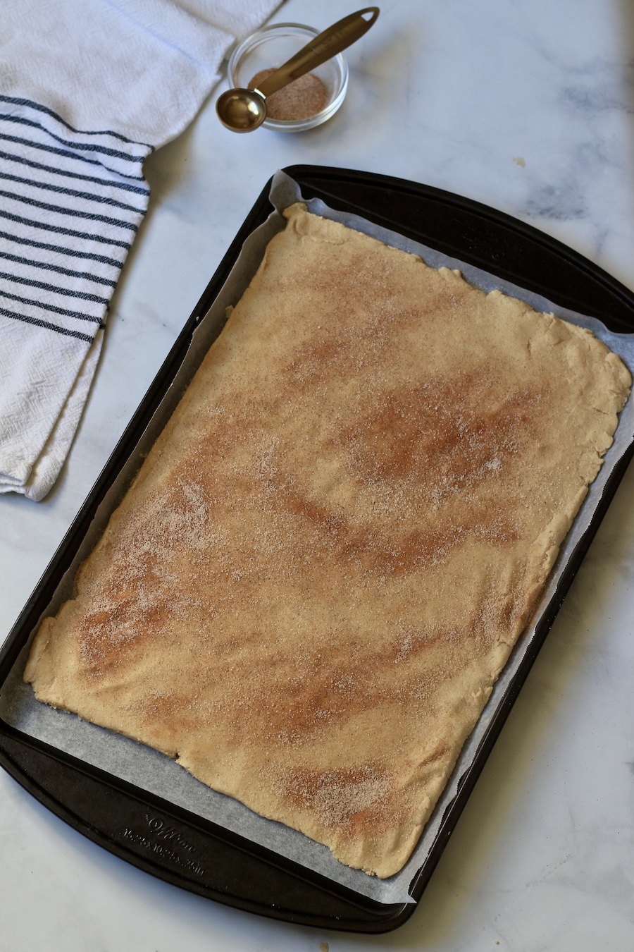 A slab of snickerdoodle cookie on a cookie sheet.
