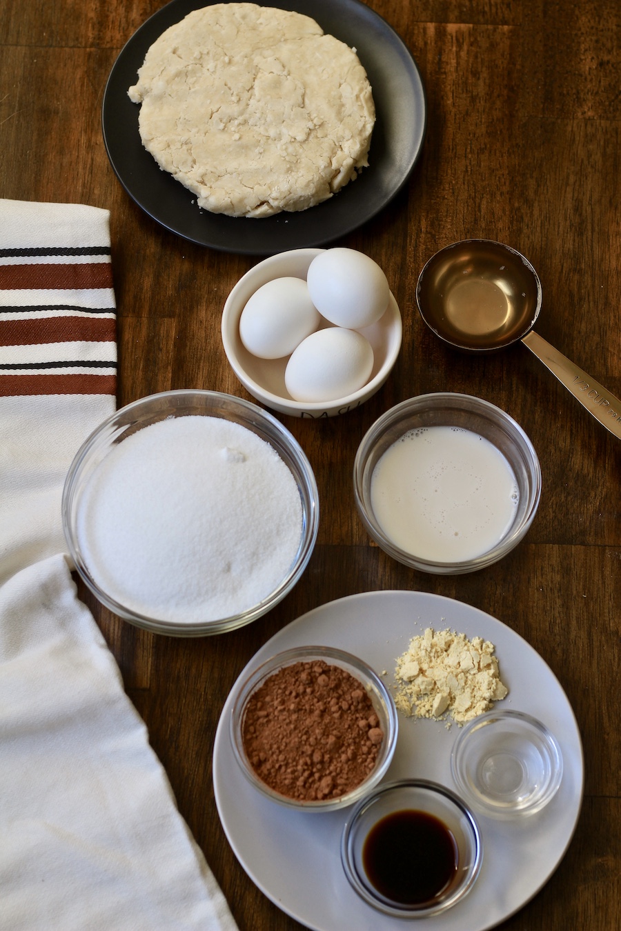 A wooden table with different ingredients in small bowls.