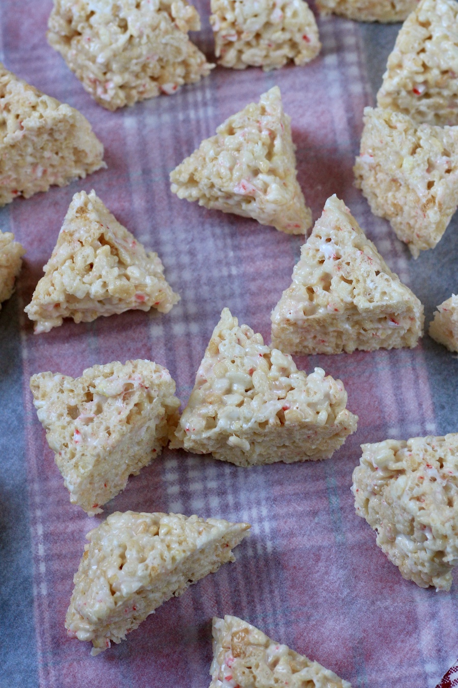 Triangle shaped rice krispies on a piece of parchment paper.
