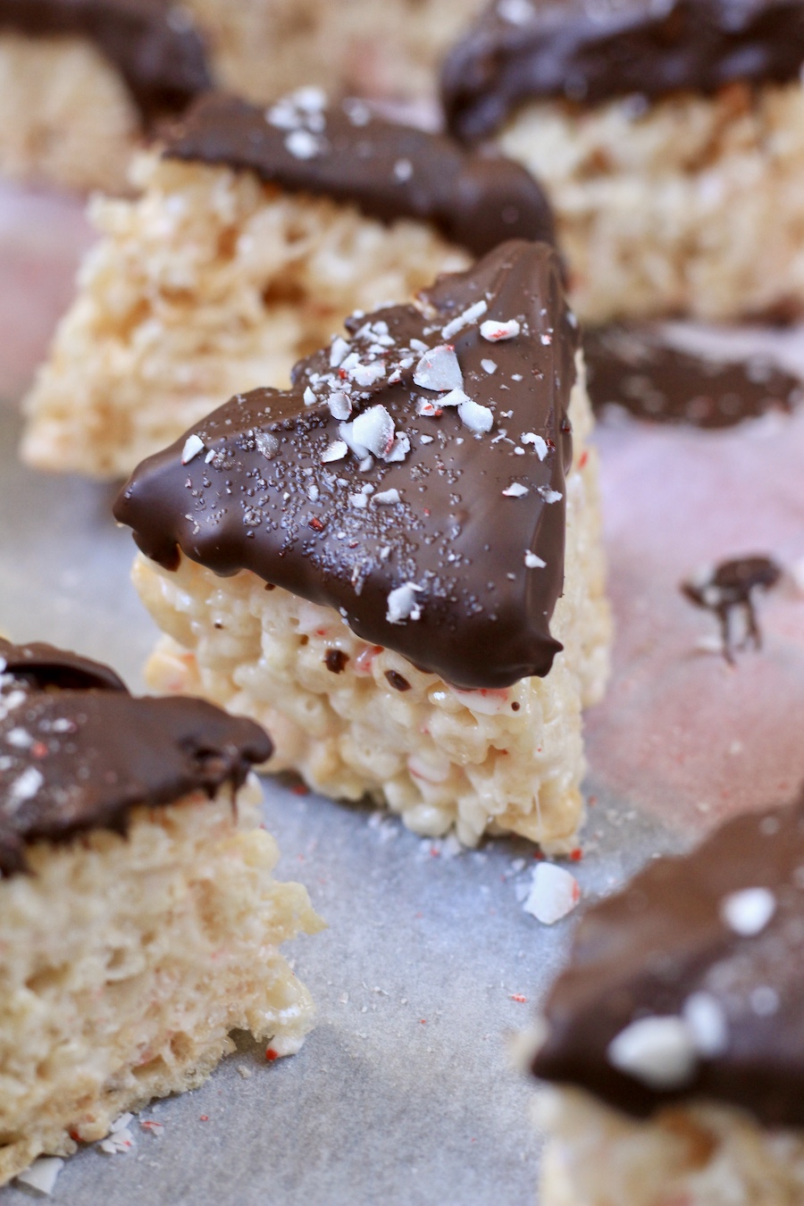 A peppermint bark rice krispie treat on parchment paper from the front angle.