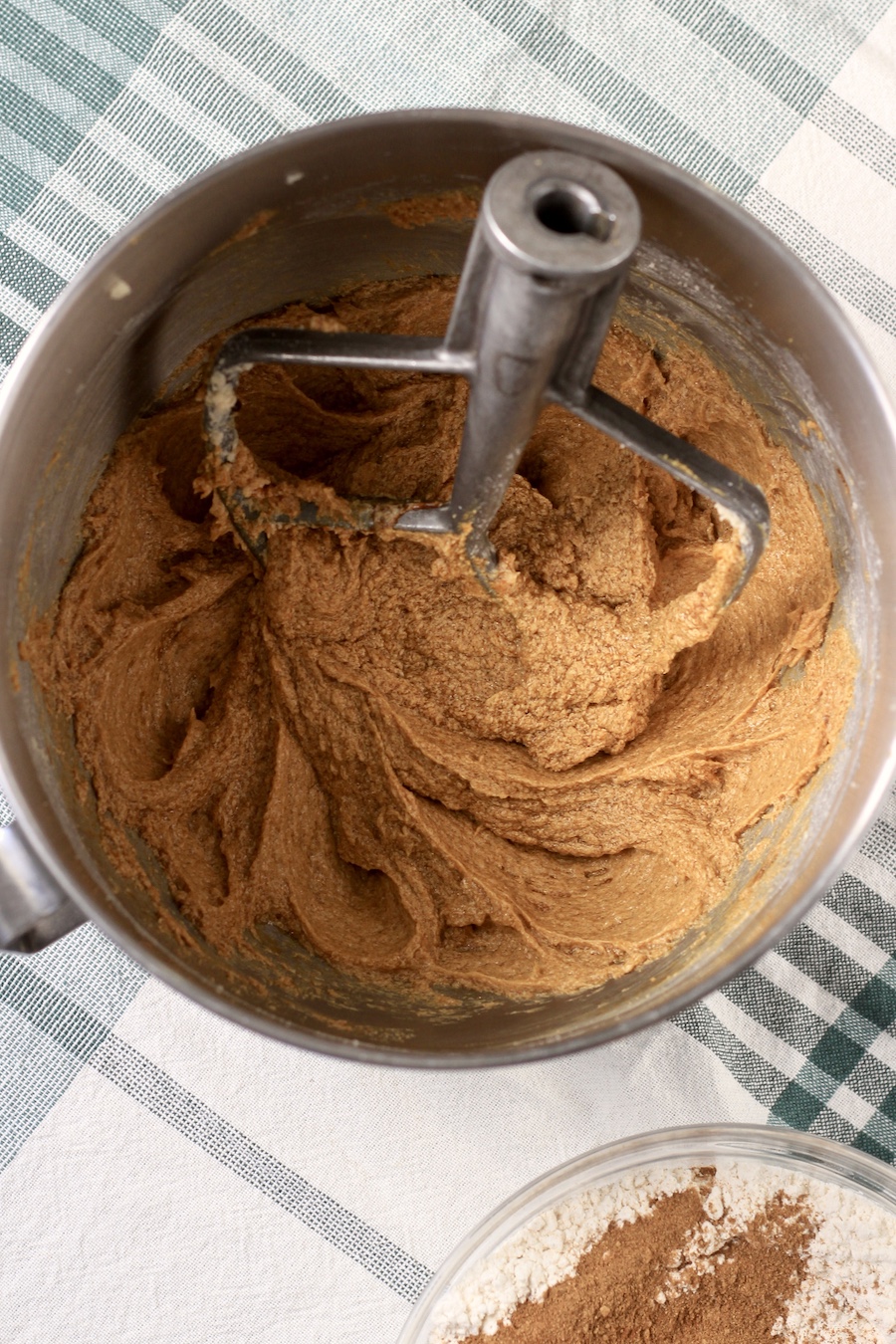 The wet ingredients creamed together in a mixing bowl with a paddle and the dry ingredients below in a glass bowl.