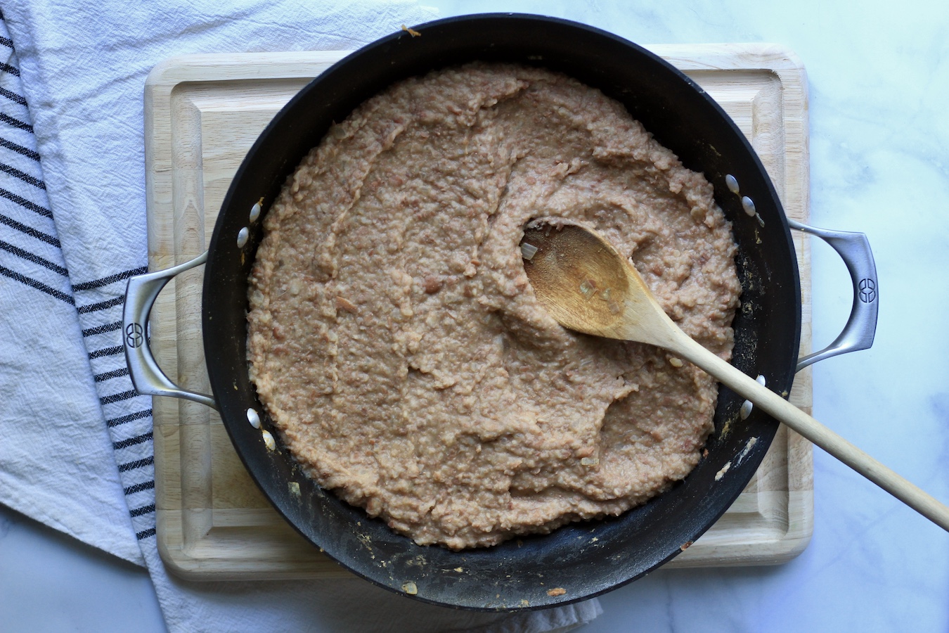 Creamy refried beans in a non-stick skillet after being blended.