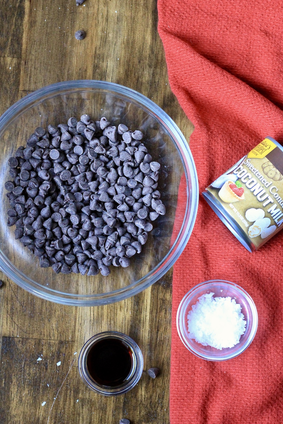 The ingredients for easy chocolate fudge on a wooden table with a red dis towel.