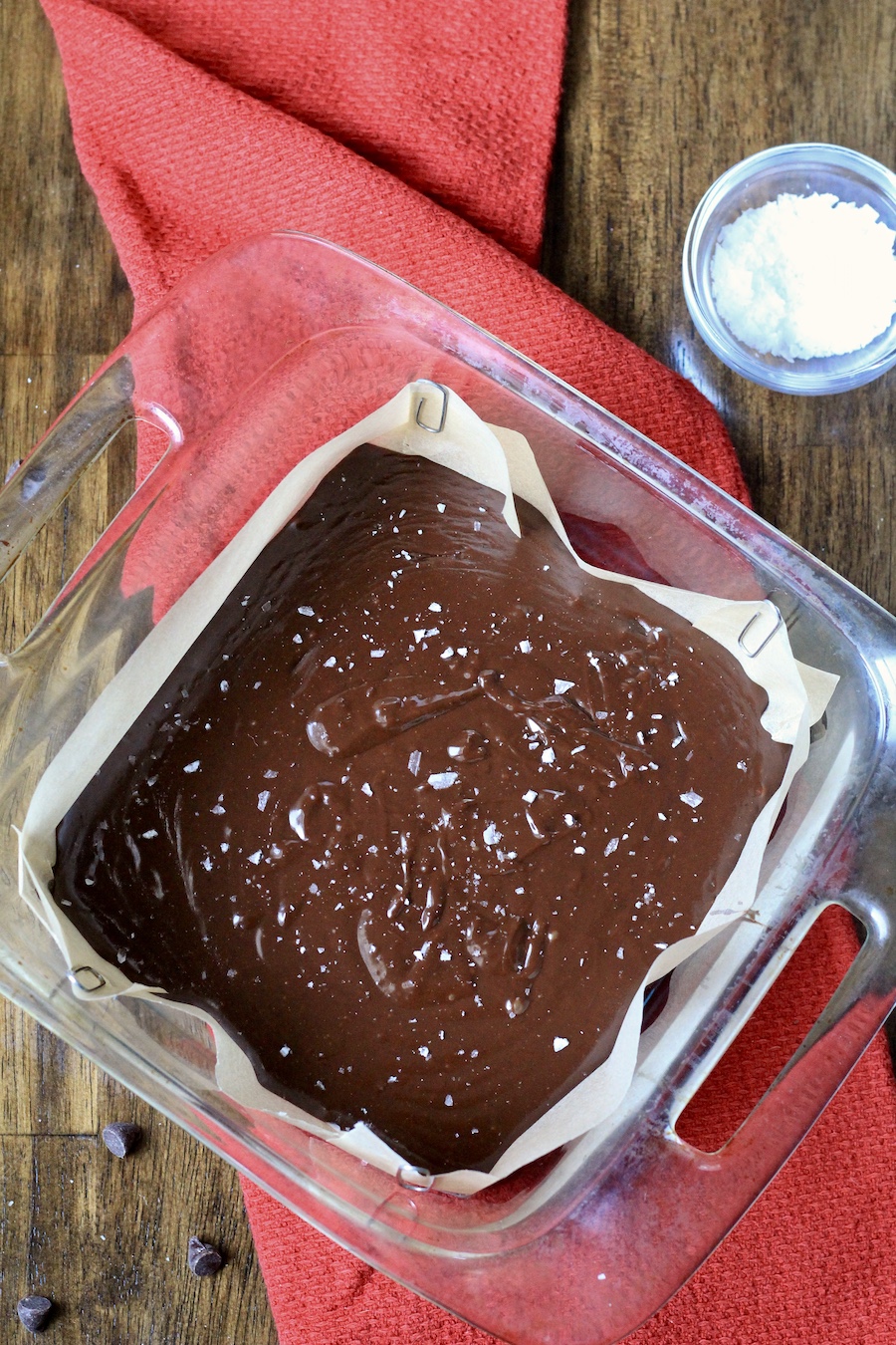 A parchment paper lined baking pan with chocolate fudge before setting.