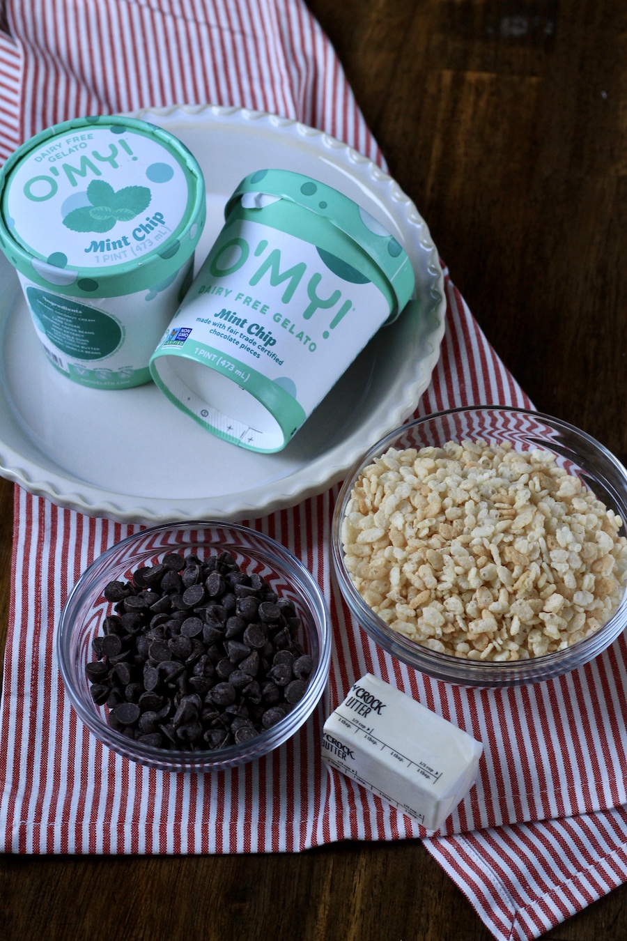 The ingredients for mint ice cream pies on a. white and red striped dish towel.