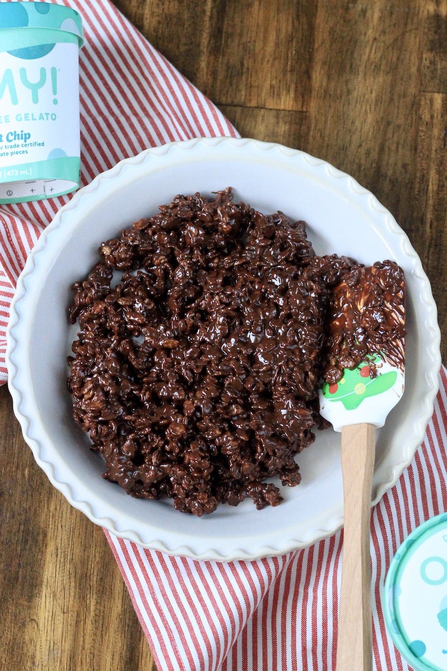 A pie pan with the pie crust not pressed in with a spatula on the right.
