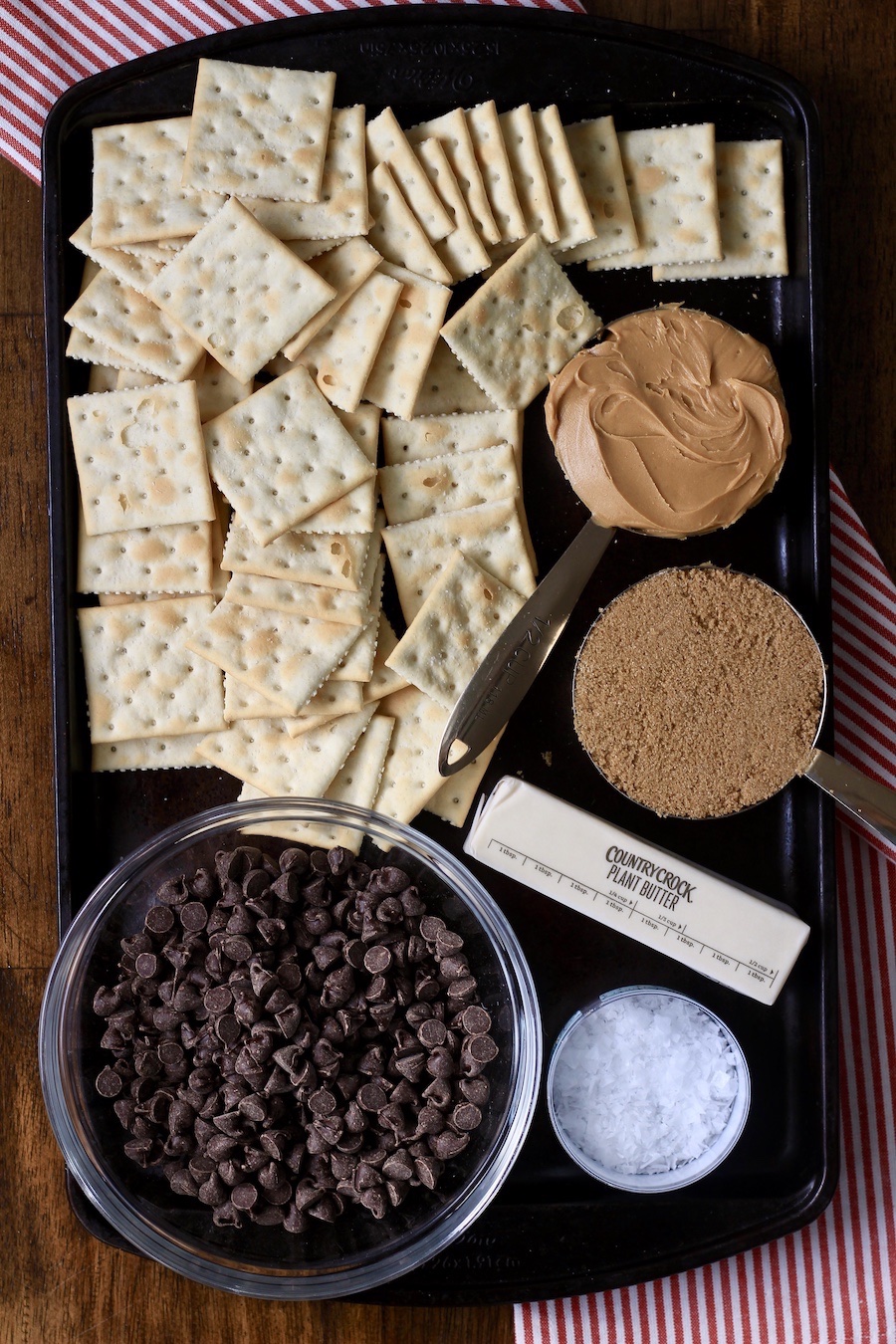 A baking sheet with the ingredients for chocolate peanut butter toffee.