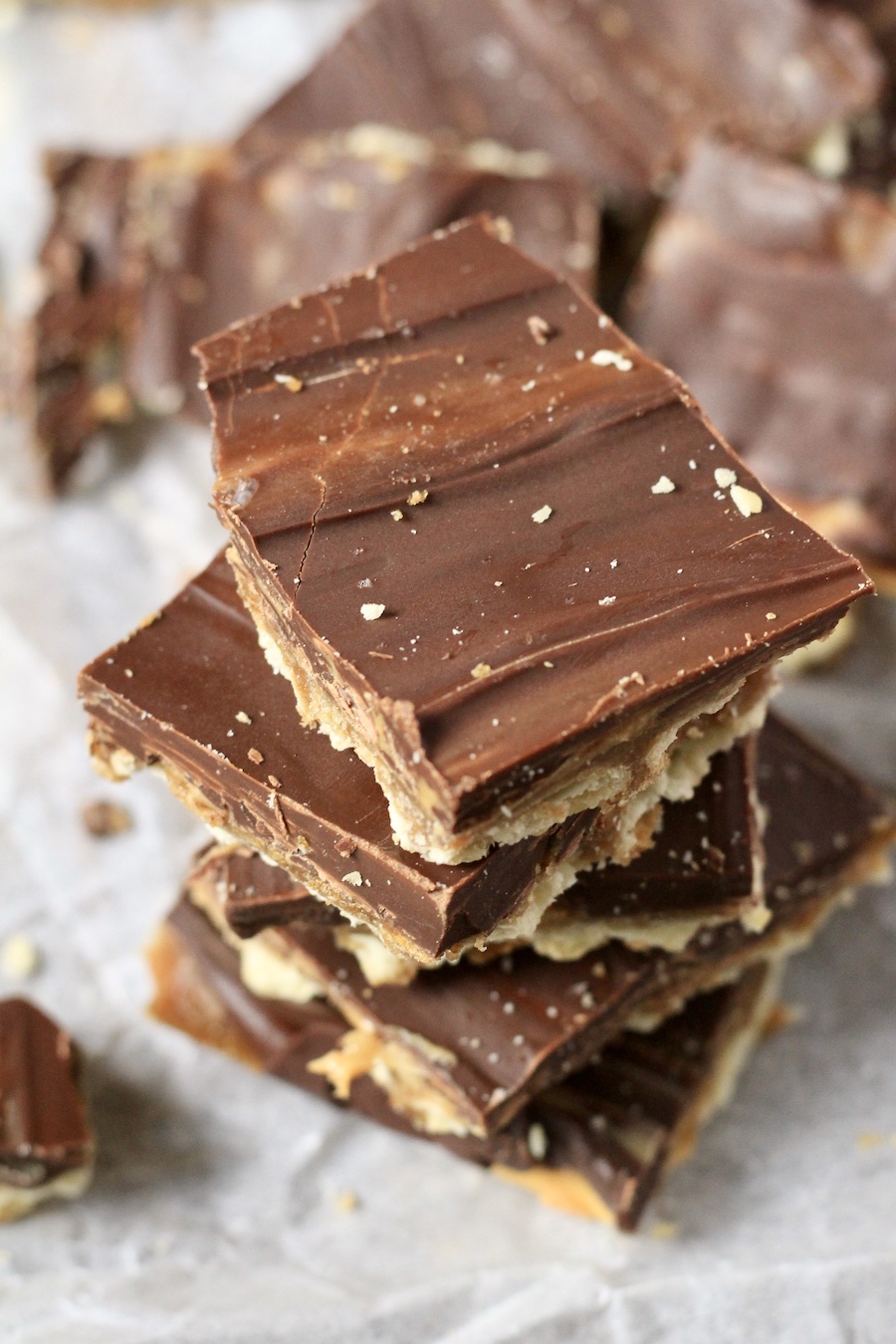 A stack of chocolate peanut butter toffee on a parchment paper.