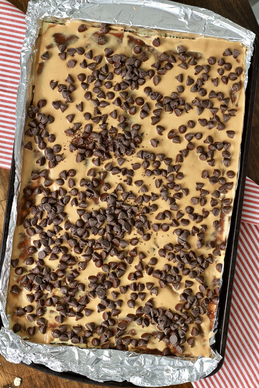 Peanut butter melted on saltines with toffee topped with chocolate chips.