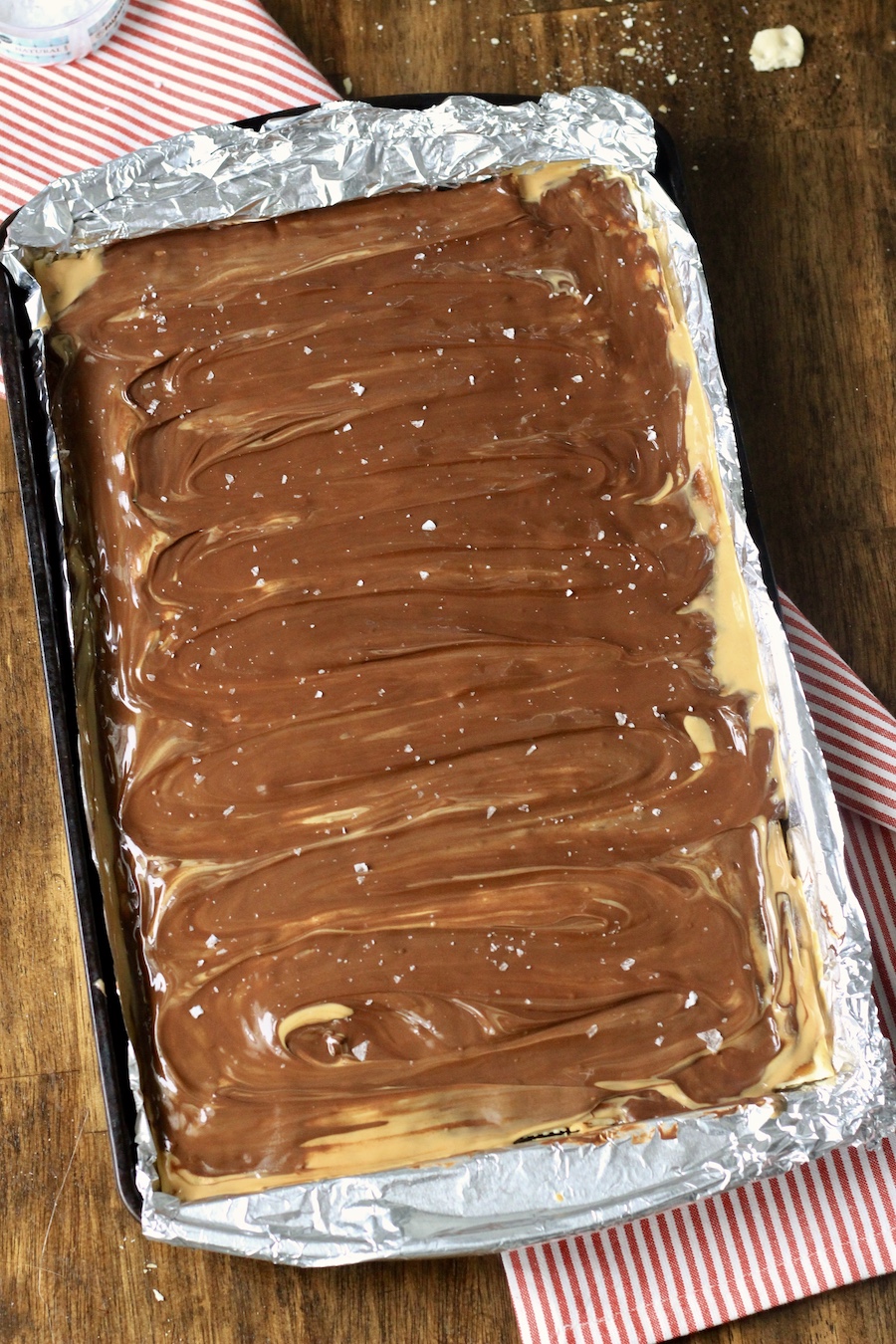 Chocolate peanut butter toffee on a foil lined baking sheet.