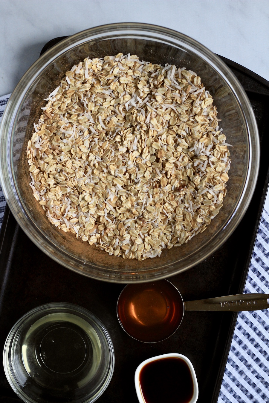 A glass bowl with dry ingredients mixed together and the liquid ingredients below.