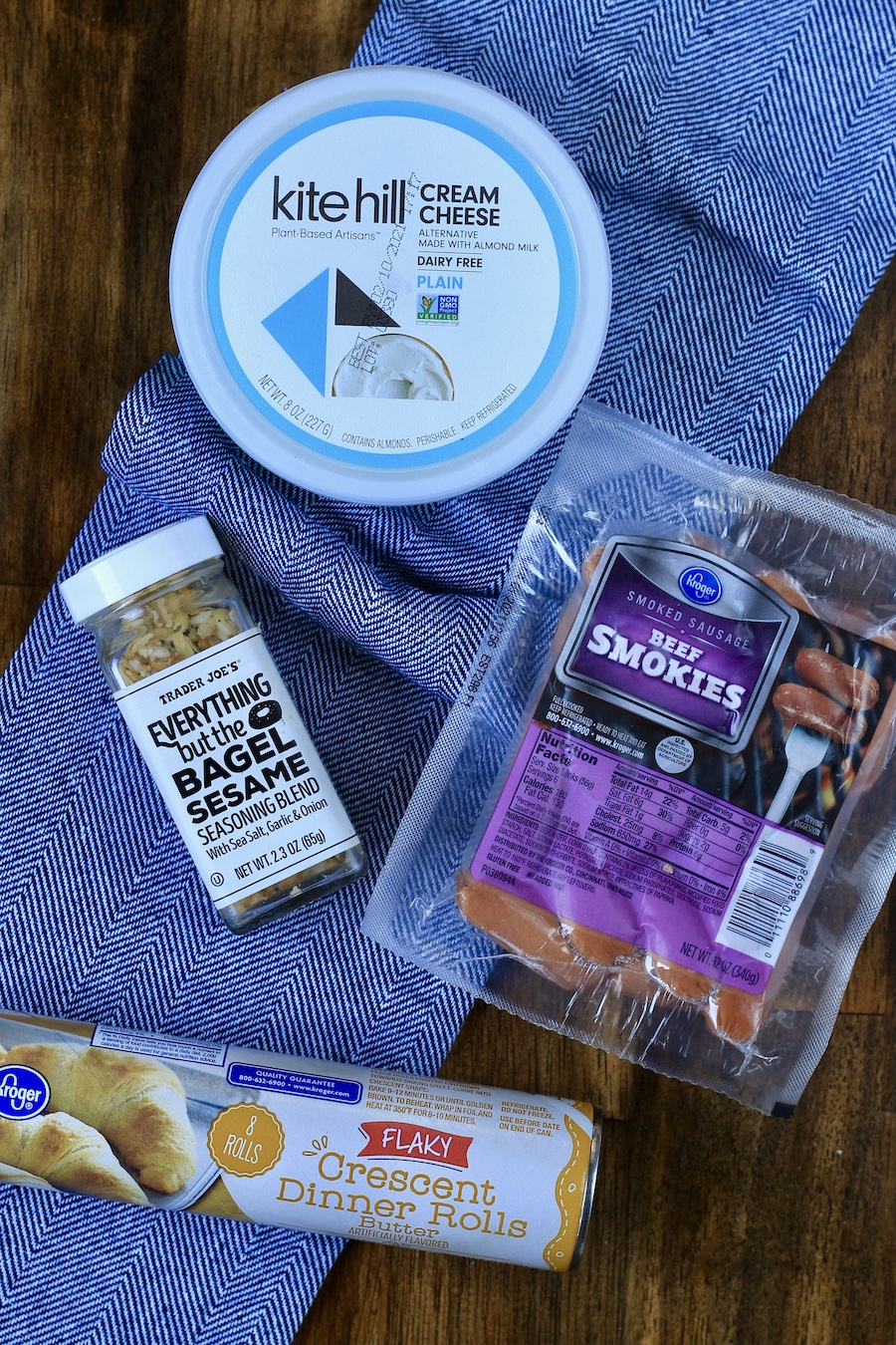 Ingredients for everything bagel pigs in a blanket on a blue towel.