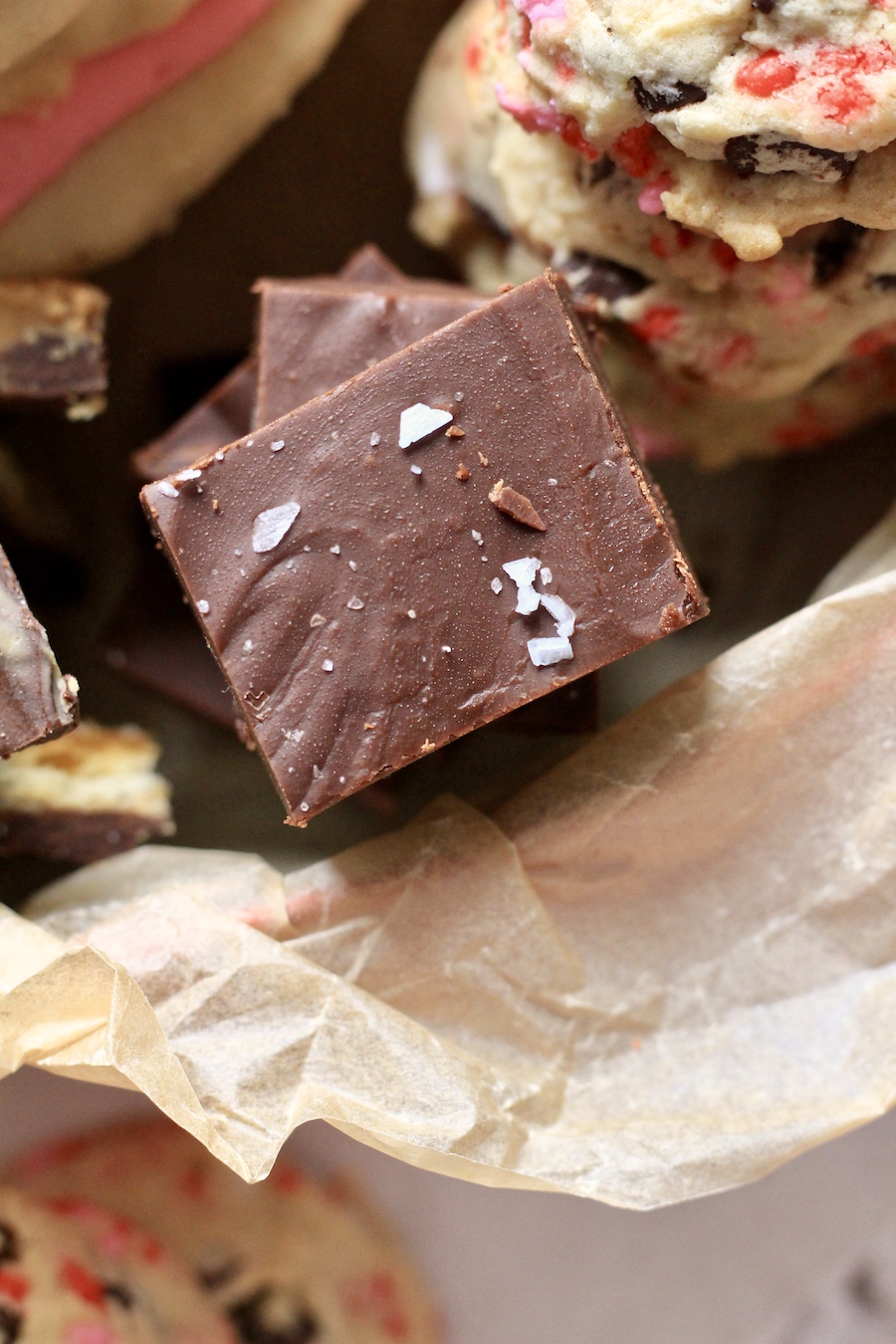 A square piece of fudge in a box with parchment paper.
