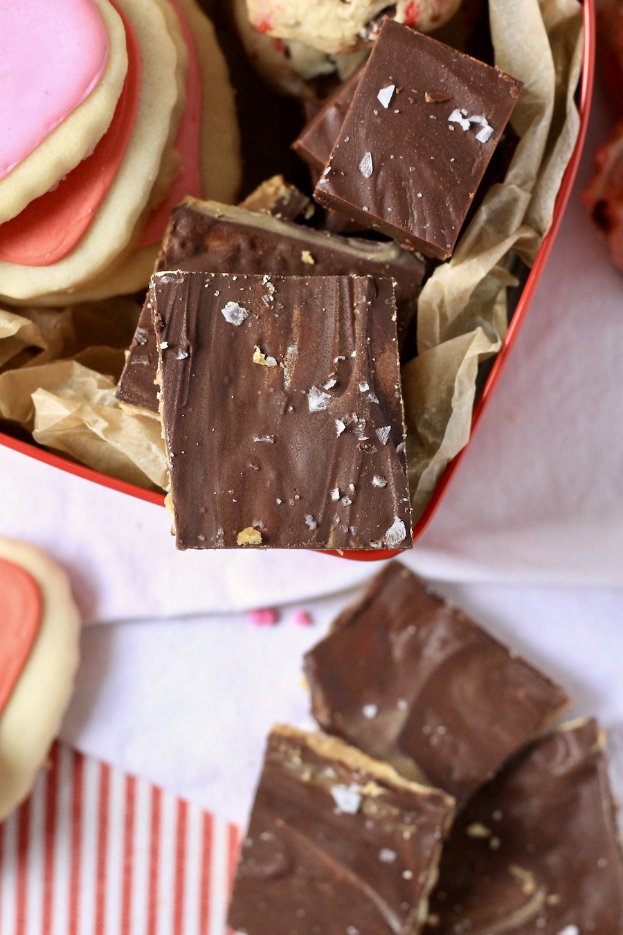 A piece of chocolate peanut butter toffee at the tip of the dessert box.