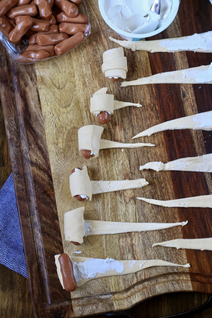 The steps for making and rolling everything bagel pigs in a blanket.