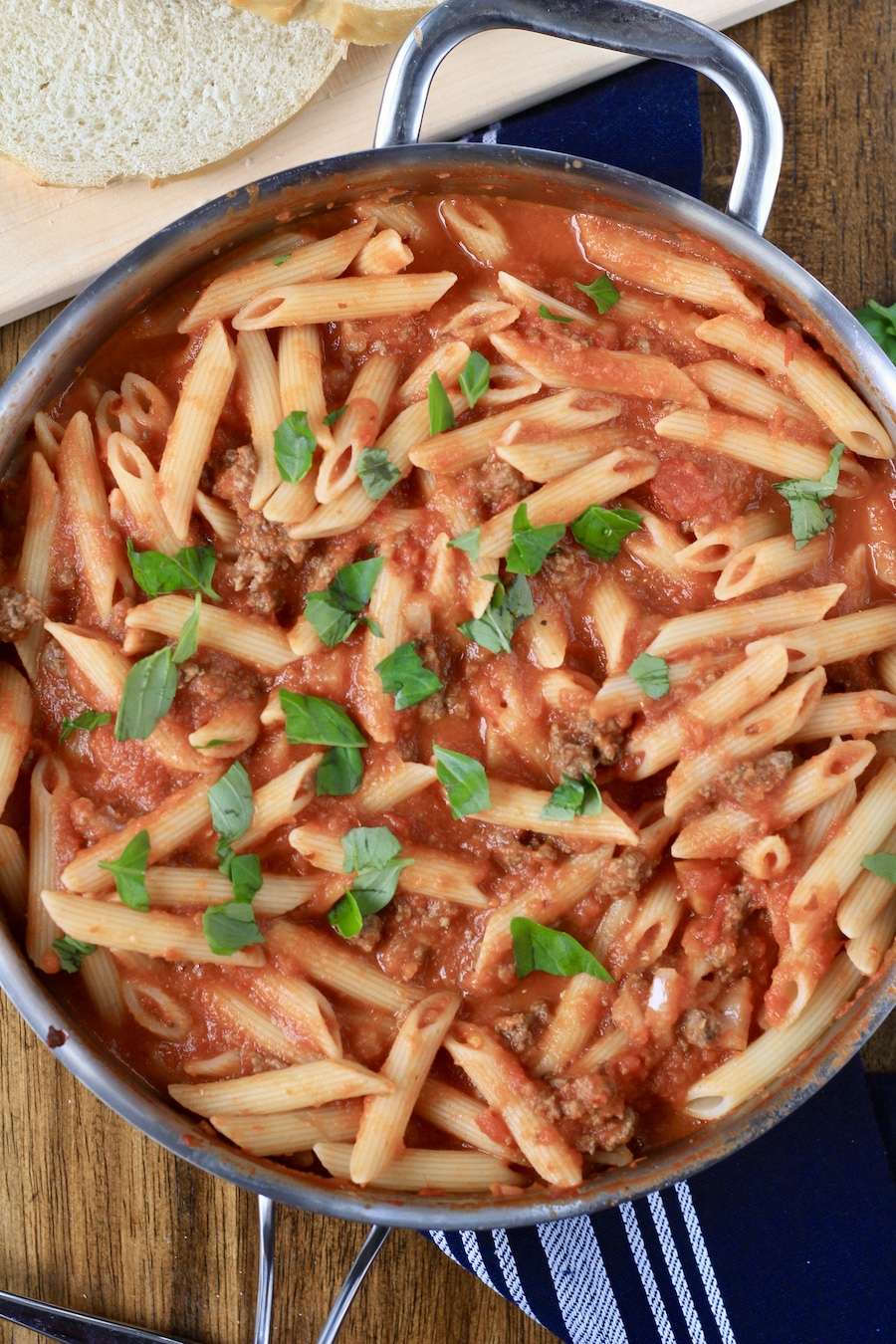 A skillet with Arrabbiata pasta topped with basil.