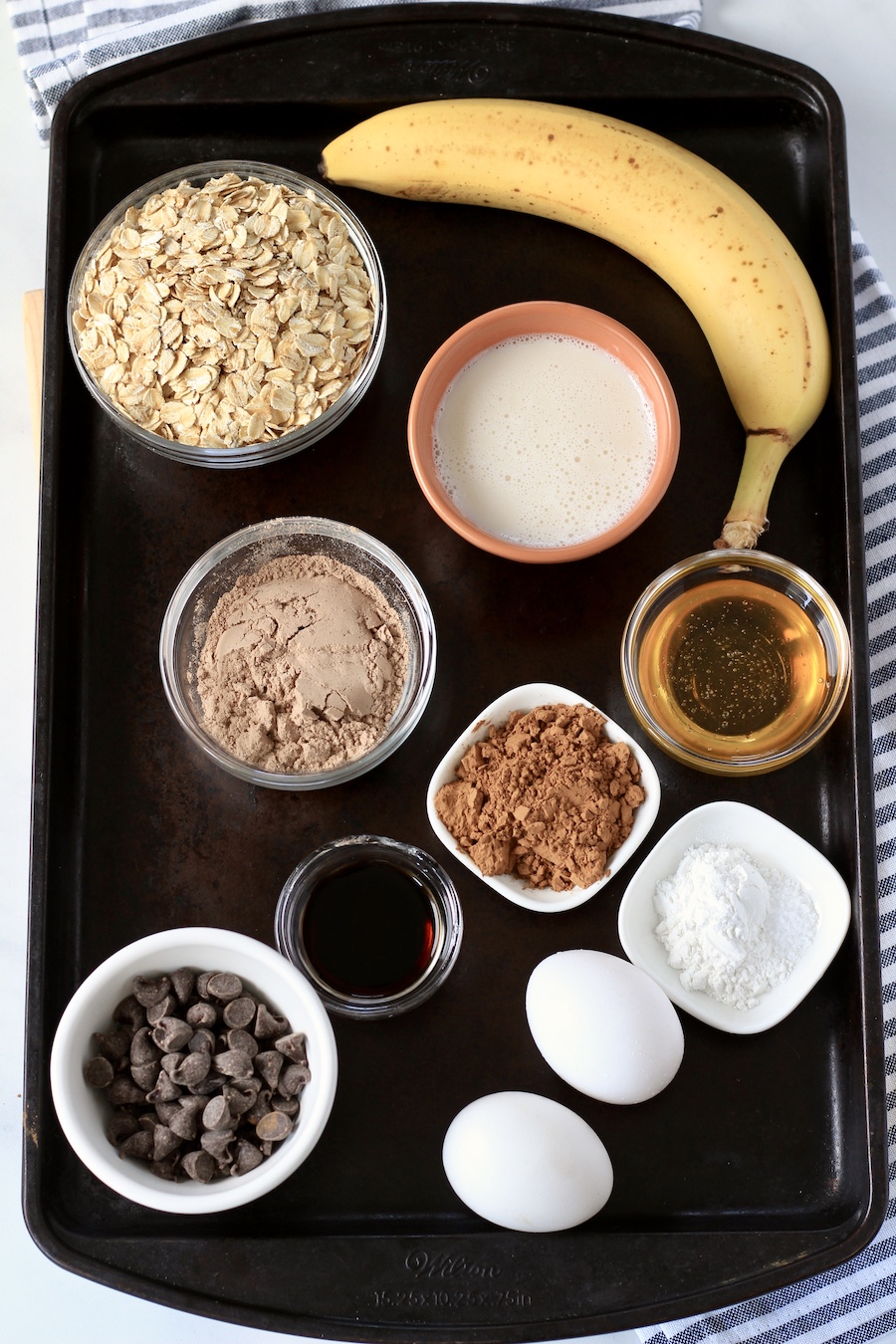A baking sheet with the ingredients for chocolate oats.