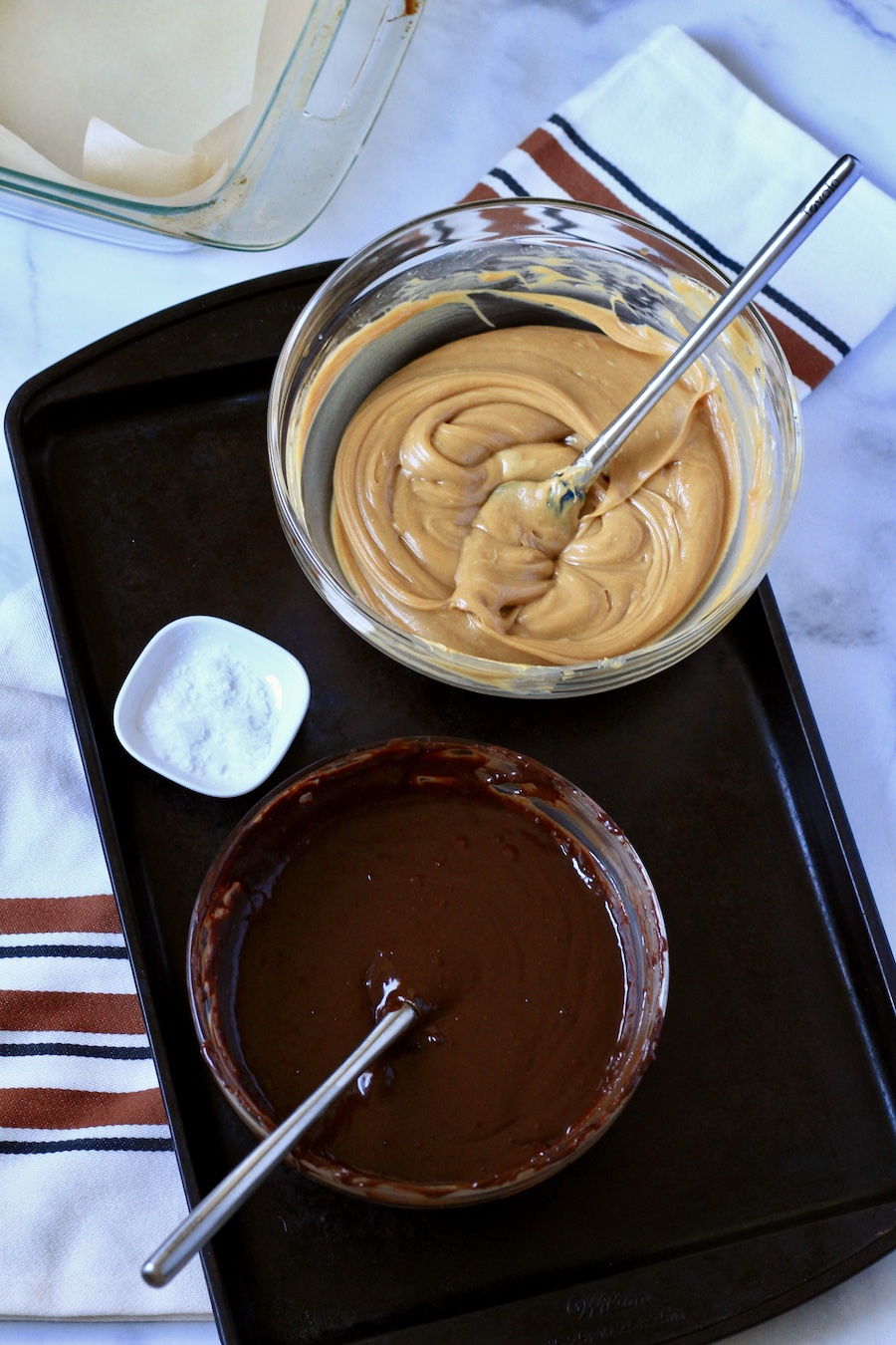 A glass bowl with peanut butter fudge in a bowl at the top and a bowl of chocolate fudge at the bottom.