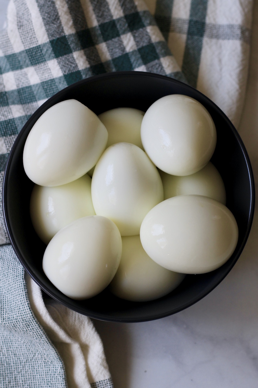 Hard boiled eggs in a blue bowl.